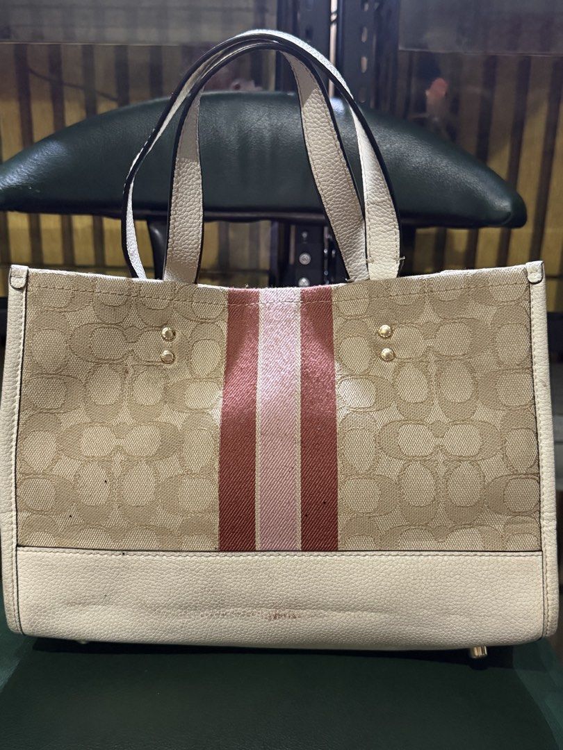 Auth Coach Dempsey Carry All Bag (Category: Luxury Bags & Wallets) located in Manila. Submitted by handpickedbycox (Listing ID 1445624314, Image 3). Description: 📌Auth Coach signature canvas tote bag - Cream base and handles - Pink and brown stripe detail on the front - Round pink patch with Coach New York logo - Ample interior space -with signs of useage -needs cleaning - No COD - No return No refund - ship via J&T ❌️BAWAL SA MASELAN.