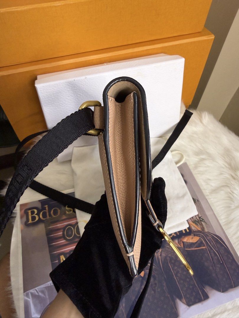 Dior Saddle Clutch Beige Leather (Category: Luxury Bags & Wallets) located in Caloocan City. Submitted by marj_bags (Listing ID 1445646416, Image 3). Description: - Authentic Dior Saddle wallet clutch - Color: Beige - Material: Textured leather - Hardware: Gold 'D' charm - Strap: Black with Dior branding - Style: Compact and stylish - Function: Ideal for essentials -Comes with dustbag and box.