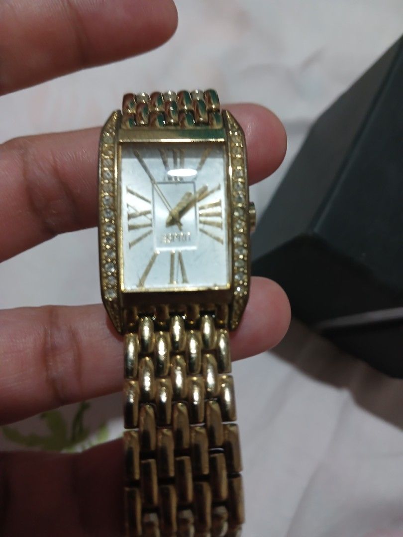 Esprit Gold Tone Watch with Rhinestones (Category: Women's Watches) located in Marikina City. Submitted by laila15 (Listing ID 1445777511, Image 3). Description: - Elegant gold tone watch - Rectangular face with Roman numeral dial - Bezel adorned with sparkling rhinestones - Classic link watch band - Includes original box - Versatile for everyday or special occasions -Available .