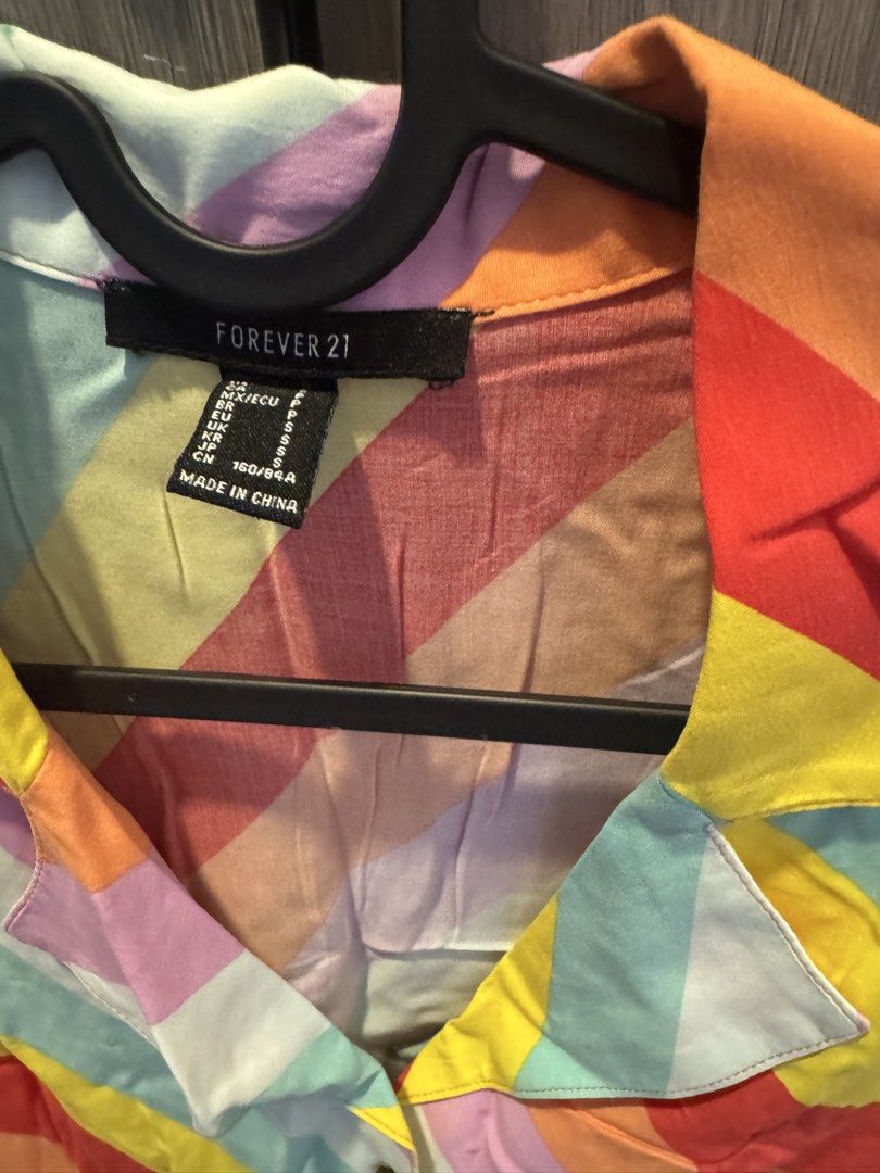 Forever 21 Rainbow Striped Button Up Shirt Top (Category: Shirts) located in Taguig. Submitted by kittychum (Listing ID 1445628620, Image 2). Description: - Cute rainbow striped button-up shirt - Brand: Forever 21 - Short sleeves with a collar - Lightweight material, ideal for warm weather - Versatile styling: pairs well with jeans or shorts - Creates a casual or fun look.