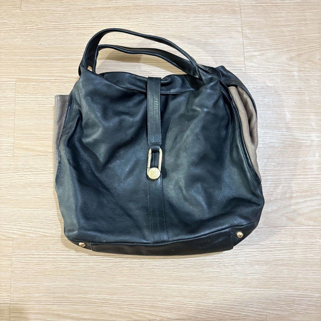 Furla Genuine Leather Hobo Bag (Category: Luxury Bags & Wallets) located in Catarman. Submitted by gadabells (Listing ID 1445670801, Image 1). Description: - Stylish black and taupe leather hobo bag - Main compartment with secure zip closure - Interior pockets for organization - Elegant gold hardware details - Shows some signs of wear, consistent with a pre-loved bag - Plenty of life remaining, great for everyday use.