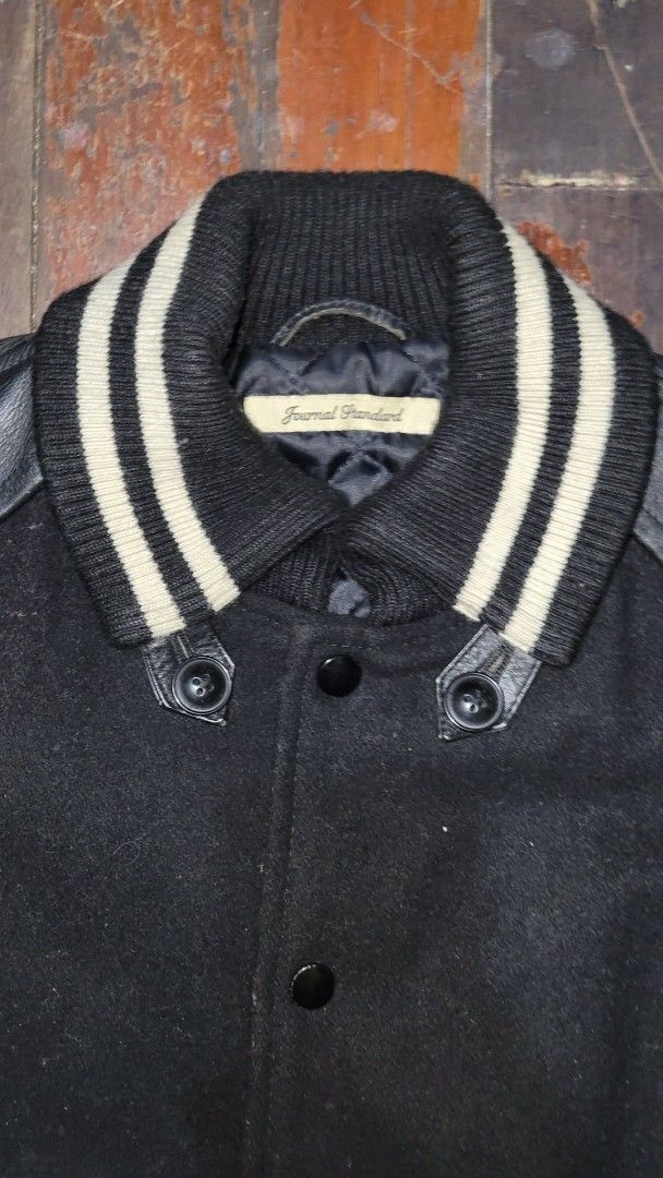 Journal Standard Black Wool Leather Varsity Jacket (Category: Coats, Jackets and Outerwear) located in Manila. Submitted by q55qb (Listing ID 1445693214, Image 2). Description: - Classic black varsity jacket by Journal Standard - Wool body with genuine leather sleeves - Ribbed collar, cuffs, and hem with white stripe detail - Quilted lining for added warmth - Button-up front closure - Perfect for layering and a timeless wardrobe addition.