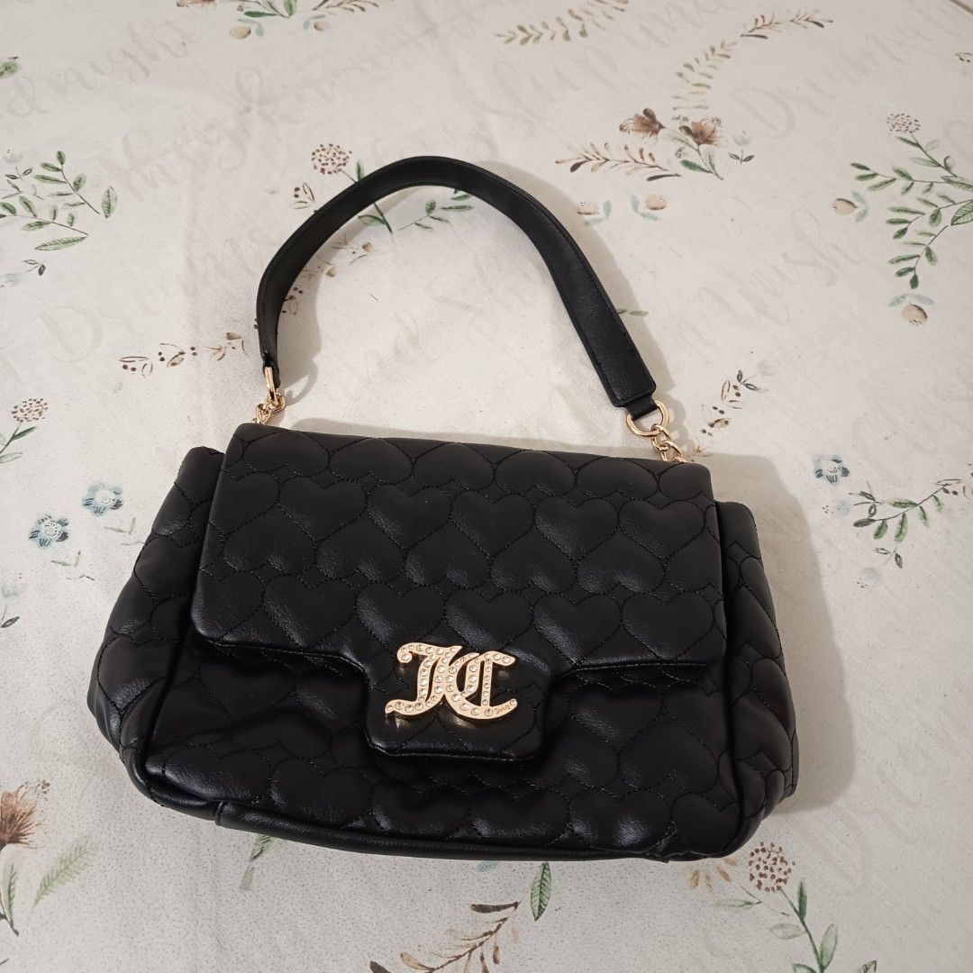Juicy Couture Black Quilted Heart Bag (Category: Luxury Bags & Wallets) located in Pasig City. Submitted by wafflestore (Listing ID 1445609846, Image 1). Description: Authentic with papertag. Never used. It's $80 uwi from the US but it doesn't match my aesthetic 🥲 Spacious with back pocket, inner pocket, and zipped pocket. Juicy Couture lining inside. Gold JC logo with rhinestones on the front flap. Quilted heart pattern. No issues. Payment thro