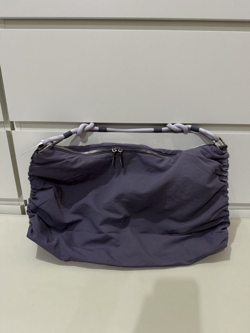 Lululemon Convertible Ruched Crossbody Bag *Large 16L - Purple (Category: Tote Bags) located in Manila. Submitted by preloved_new_forsale (Listing ID 1445768708, Image 2). Description: - Stylish purple Lululemon hobo bag - Unique gathered design with rope handles - Secure zipper closure - Interior pockets for organization - Includes an adjustable strap for versatility - Ideal for everyday wear.