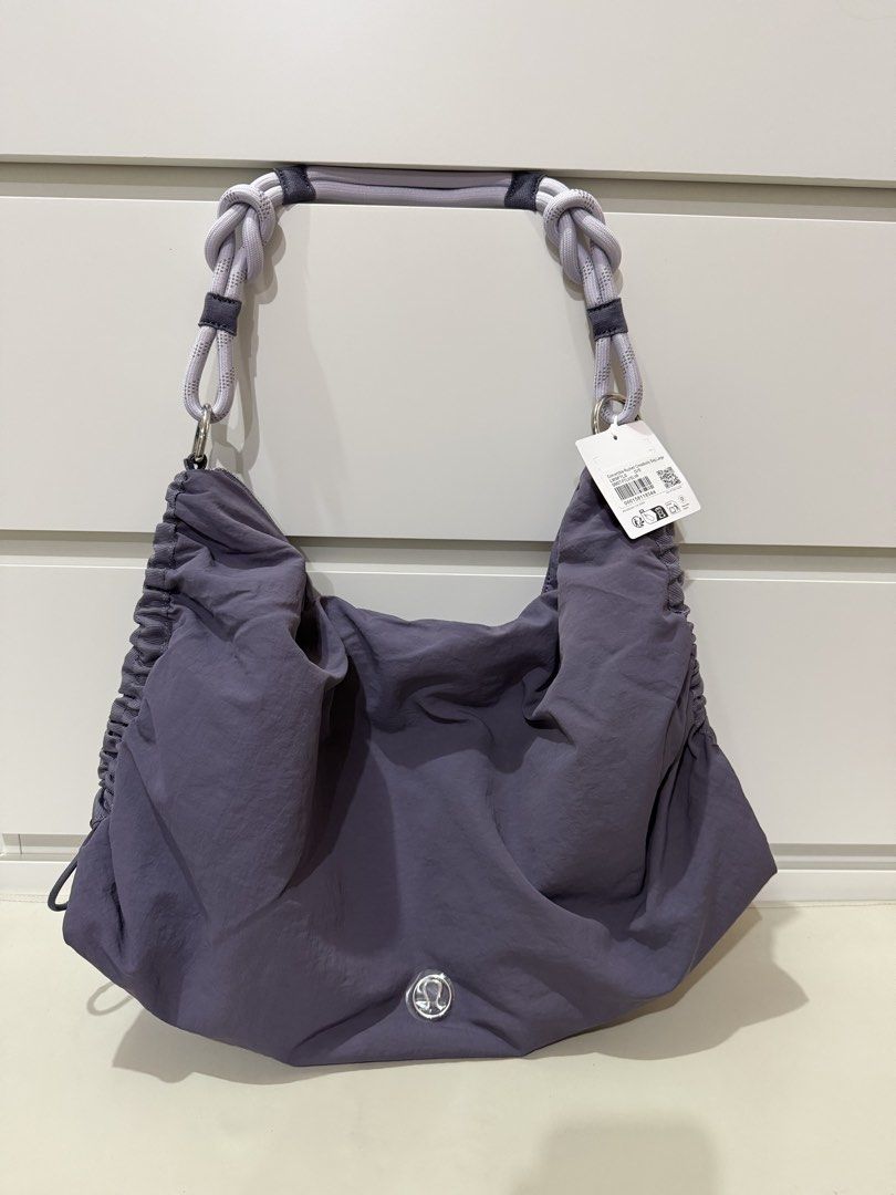 Lululemon Convertible Ruched Crossbody Bag *Large 16L - Purple (Category: Tote Bags) located in Manila. Submitted by preloved_new_forsale (Listing ID 1445768708, Image 1). Description: - Stylish purple Lululemon hobo bag - Unique gathered design with rope handles - Secure zipper closure - Interior pockets for organization - Includes an adjustable strap for versatility - Ideal for everyday wear.
