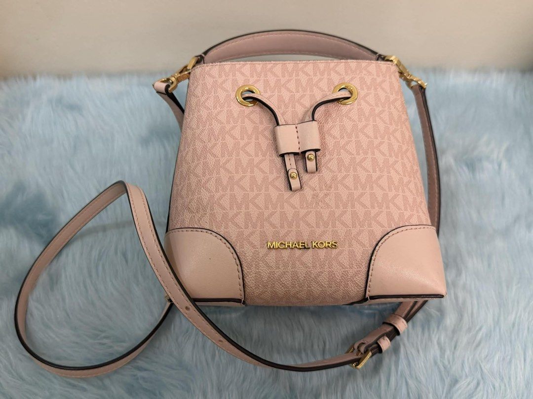 Michael Kors Pink Monogram Bucket Bag (Category: Luxury Bags & Wallets) located in Manila. Submitted by mommynikaden (Listing ID 1445744388, Image 1). Description: - Authentic Michael Kors bucket bag - Classic MK monogram print in pink - Secure drawstring closure - Convenient top handle - Includes a detachable crossbody strap for versatile wear - Soft pink leather trim - Elegant gold hardware details - Ideal for everyday use.