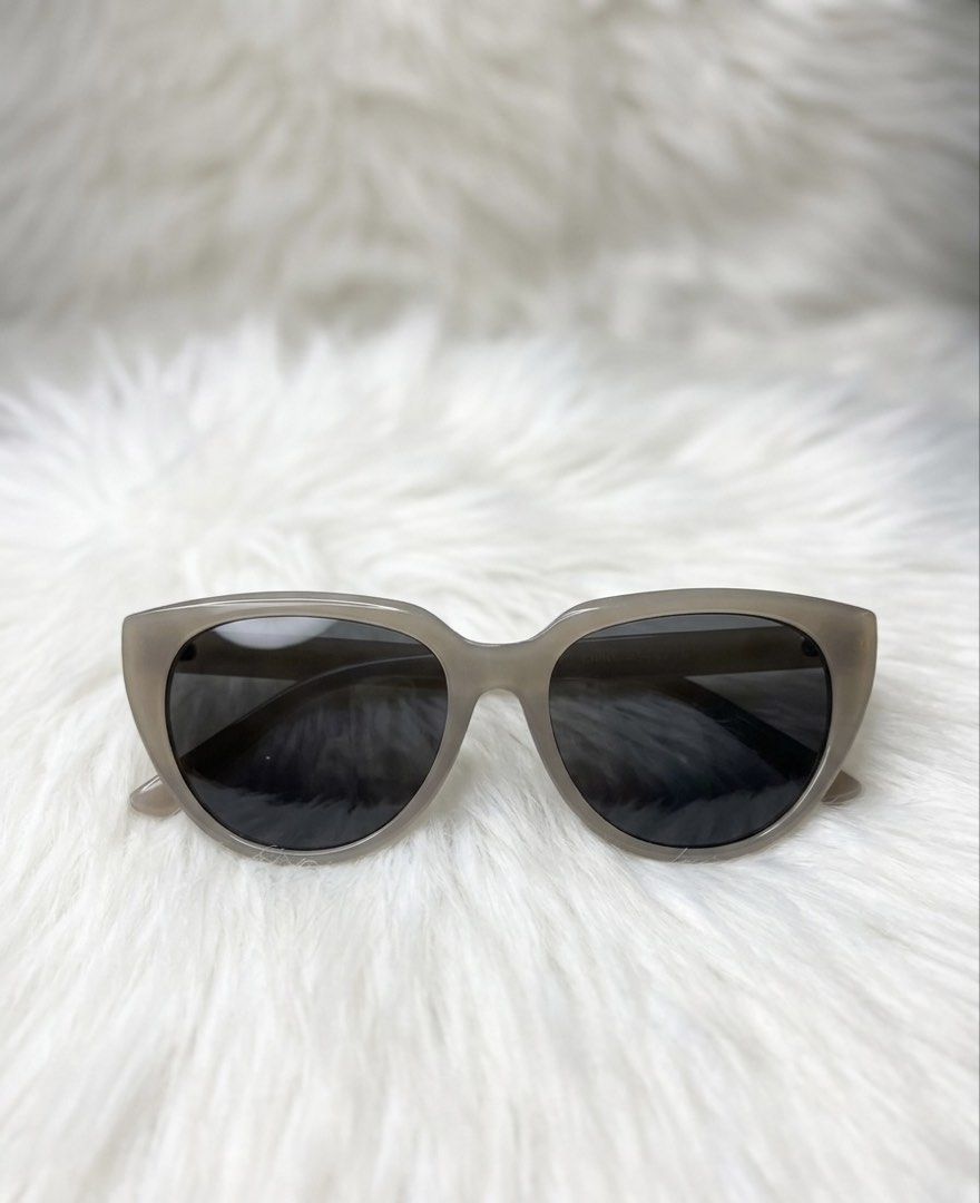 Minimalist Translucent Taupe Cat-Eye Sunglasses (Category: Sunglasses & Eyewear) located in Manila. Submitted by buyretreasurehubnow (Listing ID 1445737212, Image 1). Description: Design: Sleek soft cat-eye/butterfly silhouette with a thick, smooth frame. Color: Translucent Taupe / Milky Gray-Beige—a very trendy, understated neutral tone. Lenses: Solid dark gray/black tinted lenses providing great sun protection. Condition: Excellent pre-loved co