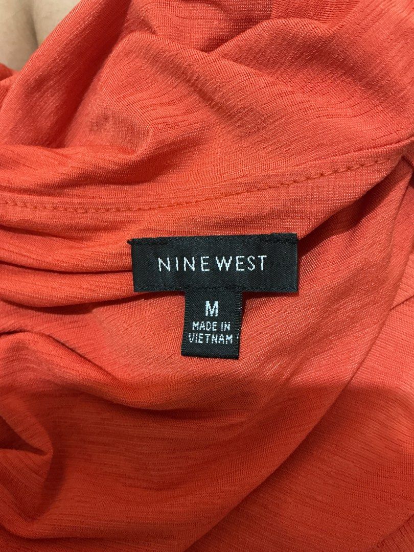 Nine West Orange Ruched Square Neck Top Size M (Category: Blouses) located in Hamtic. Submitted by crispicks (Listing ID 1445742465, Image 3). Description: - Brand: Nine West - Color: Orange - Size: Medium (M) - Features: Ruched detail across neckline, short sleeves - Fabric: Subtle texture - Origin: Made in Vietnam.