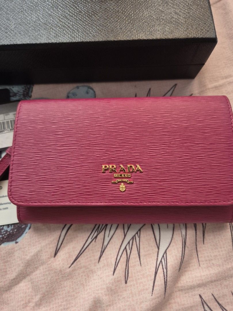 Prada Saffiano Leather Wallet Pink (Category: Luxury Bags & Wallets) located in Quezon City. Submitted by ctatel (Listing ID 1445684561, Image 2). Description: - Authentic Prada wallet - Vibrant pink Saffiano leather - Gold tone hardware - Zipper closure - Detachable wrist strap - Includes original box and authenticity cards - Spacious interior for cards and cash.
