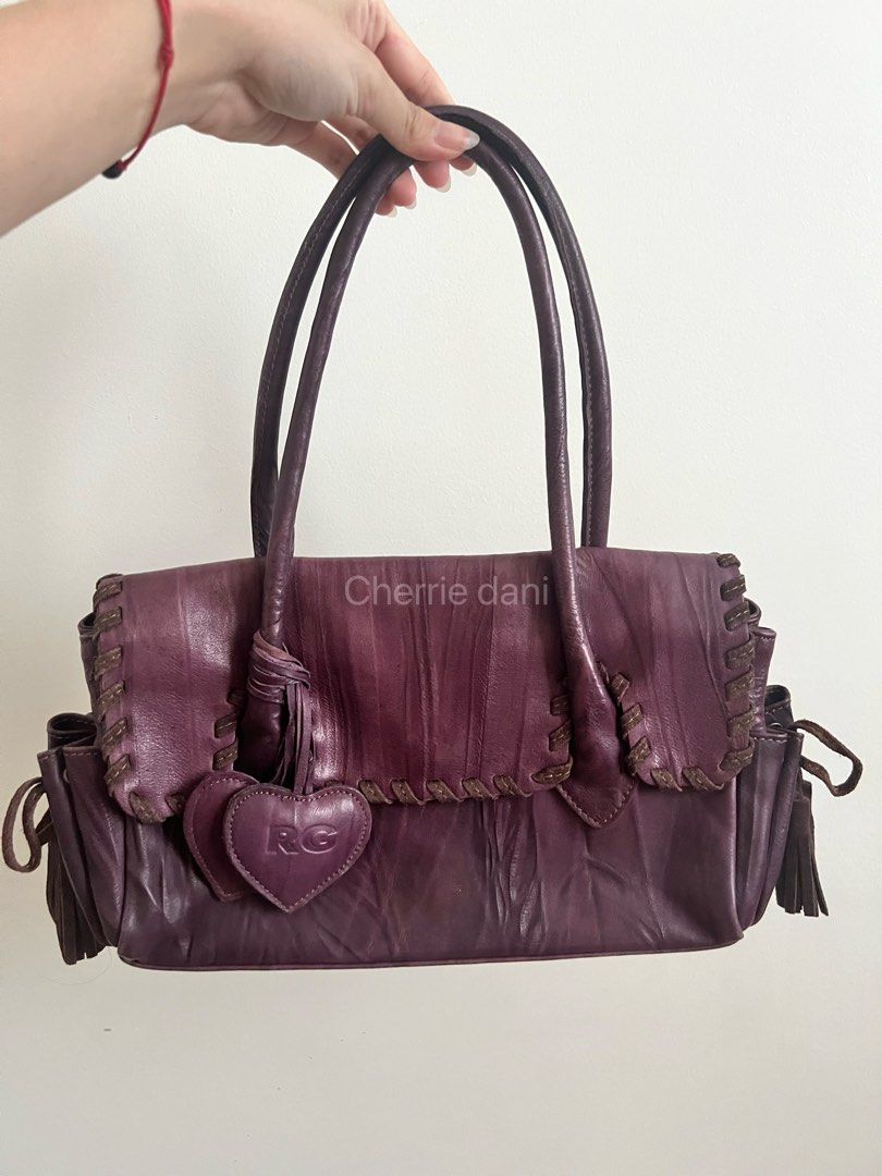 Roberta Gandolfi Purple Leather Handbag (Category: Luxury Bags & Wallets) located in Manila. Submitted by cherrie_dani (Listing ID 1445660996, Image 1). Description: LAST PRICE POSTED - Eye-catching purple leather handbag - Unique stitching details for a distinctive look - Adorable heart charm with 'RG' logo - Trendy side tassels and handle tassel detail - Ample interior space for all your essentials - Ideal for everyday use and stylish outings.