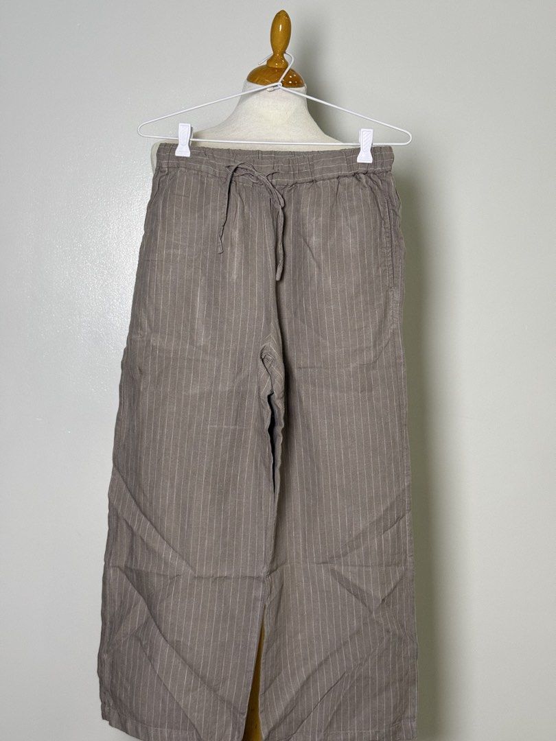 Muji Striped Wide Leg Pants with Drawstring Waist (Category: Other Bottoms) located in Manila. Submitted by iloveyouna_ (Listing ID 1445741000, Image 2). Description: - Grey striped wide leg pants - Comfortable drawstring waist - Lightweight fabric (likely linen blend) - Wide legs with stylish split hem - Versatile for casual wear or lounging - Easy to dress up or down Waist: 30” Length: 35”.