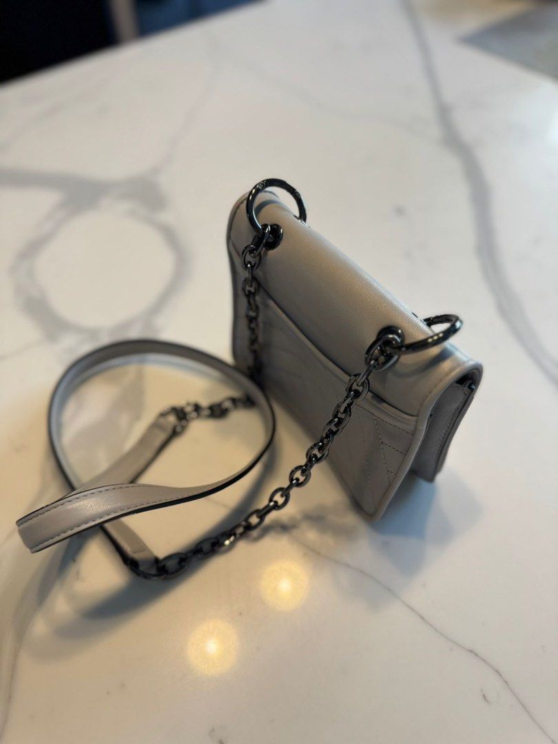 Tory Burch Kira Chevron Small Flap Bag Grey (Category: Luxury Bags & Wallets) located in Las Pinas. Submitted by biscoff.26 (Listing ID 1445721936, Image 1). Description: - Authentic Grey Tory Burch Kira bag - Small size, perfect for essentials - Quilted chevron pattern with signature double T logo - Versatile strap options: chain strap and leather shoulder strap - Stylish gunmetal hardware - Interior and exterior are clean .
