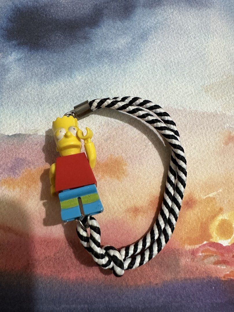 Bart Simpson Lego Keychain with Black and White Rope (Category: Character Goods) located in Naga. Submitted by bag.net (Listing ID 1445931740, Image 2). Description: - Cute Bart Simpson keychain (from Japan 🇯🇵 ₱ - Lego-style figure - Braided black and white rope - Durable metal clasp - Ideal for bags, keys, or as a fun accessory for any fan -collectible item!!!(rare).