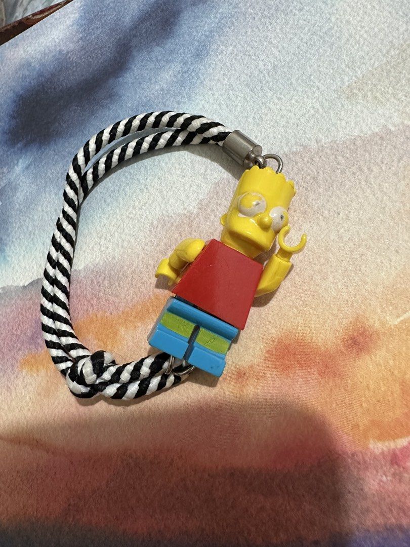 Bart Simpson Lego Keychain with Black and White Rope (Category: Character Goods) located in Naga. Submitted by bag.net (Listing ID 1445931740, Image 1). Description: - Cute Bart Simpson keychain (from Japan 🇯🇵 ₱ - Lego-style figure - Braided black and white rope - Durable metal clasp - Ideal for bags, keys, or as a fun accessory for any fan -collectible item!!!(rare).