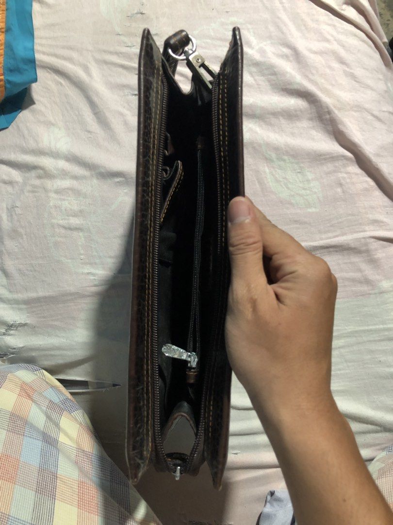 Brown Leather Clutch Bag with Wrist Strap (Category: Belt bags, Clutches and Pouches) located in Munoz. Submitted by bb_jimbo0 (Listing ID 1445942305, Image 2). Description: - Dark brown textured leather clutch - Detachable wrist strap included - Multiple interior compartments for organization - Zippered pocket for secure storage - Dimensions: Approximately 10 inches x 6 inches.