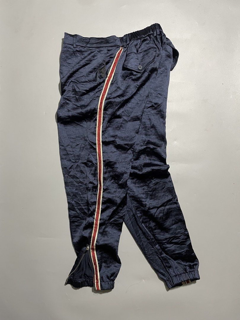 Gucci Ankle Zipped Jogger Pants (Category: Luxury Apparel) located in Taguig. Submitted by sellnbustle (Listing ID 1445890247, Image 1). Description: Gucci Navy Blue Ankle Zipped Jogger Pants Size Large 30 Waist 38.5” Length Excellent condition - Gucci navy blue track pants - Signature red and white stripe down the side - Elastic waistband with drawstring for adjustable fit - Zippers at the ankle for styling options - Made in Italy - Ideal for ca