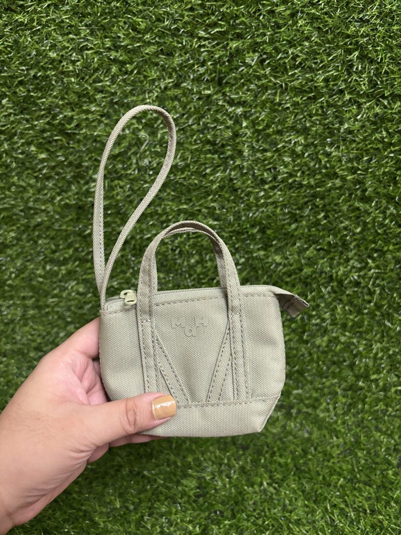 MAH mini wallet in Cactus Green (Category: Wallets & Card holders) located in Valenzuela. Submitted by graciadianna (Listing ID 1445959888, Image 2). Description: - Adorable MAH coin pouch - Unique mini tote bag shape - Secure zipper closure - Chic light sage green canvas material - Ideal for organizing small essentials like coins, cards, or earbuds.