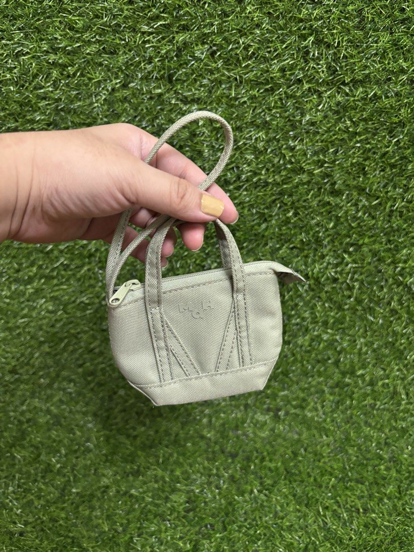 MAH mini wallet in Cactus Green (Category: Wallets & Card holders) located in Valenzuela. Submitted by graciadianna (Listing ID 1445959888, Image 1). Description: - Adorable MAH coin pouch - Unique mini tote bag shape - Secure zipper closure - Chic light sage green canvas material - Ideal for organizing small essentials like coins, cards, or earbuds.