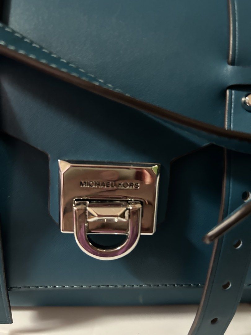 Michael Kors Manhattan Satchel Bag (Category: Luxury Bags & Wallets) located in Manila. Submitted by dragon.lady1 (Listing ID 1445815241, Image 2). Description: - Authentic Michael Kors Manhattan Satchel - Color: Teal. Excellent condition - Silver hardware and all-over stud details - Top handle or adjustable crossbody strap - Secure front flap with a lock closure - Interior includes a zip pocket and fabric lining .
