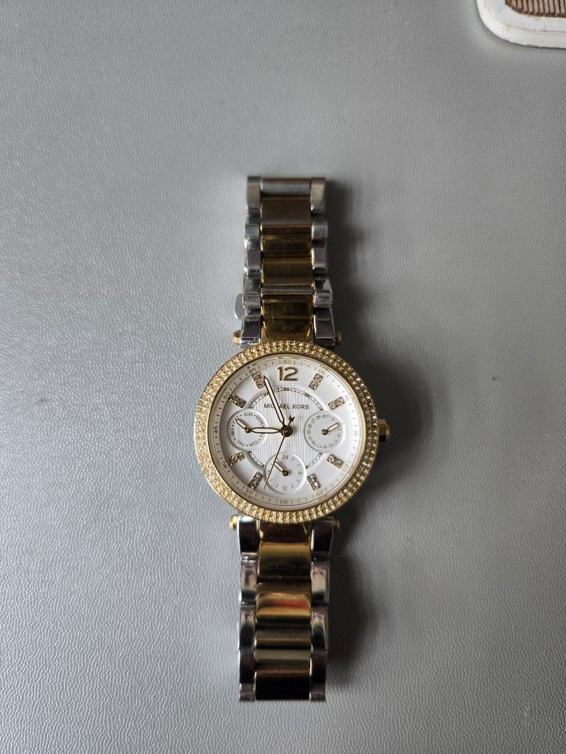 Michael Kors Two-Tone Chronograph Watch (Category: Luxury Watches) located in Quezon City. Submitted by mgdeclutters (Listing ID 1445849063, Image 1). Description: - Michael Kors Two-Tone Watch (Gold & Silver Stainless Steel) - White Dial with Chronograph Functions - Bezel encrusted with small stones - Water Resistant up to 10 ATM - Secure Clasp - Versatile for everyday or dressy wear.