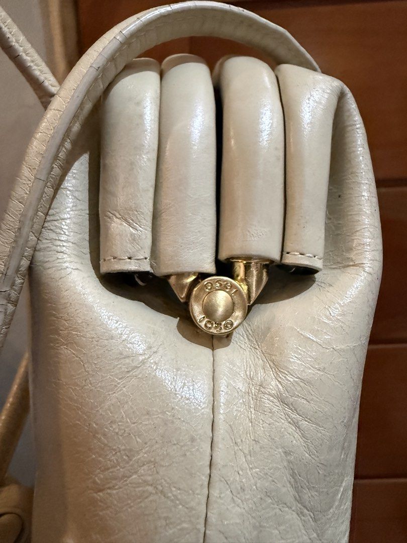 OSOI Cream Leather Handbag 💯 (Category: Luxury Bags & Wallets) located in El Nido. Submitted by isla.vintage (Listing ID 1445837636, Image 2). Description: - Signs of usage are well visible - Cream leather shoulder bag - Unique fist-shaped handle closure - Gold hardware accents 📍Palawan Mod: Lbc/Jnt Mop: Gcash/Maya/Bank Transfer Sf to be shouldered by buyer .