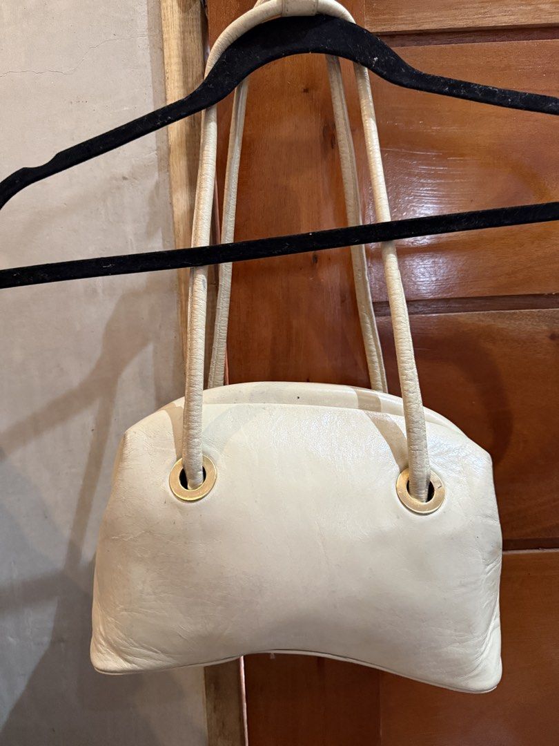 OSOI Cream Leather Handbag 💯 (Category: Luxury Bags & Wallets) located in El Nido. Submitted by isla.vintage (Listing ID 1445837636, Image 3). Description: - Signs of usage are well visible - Cream leather shoulder bag - Unique fist-shaped handle closure - Gold hardware accents 📍Palawan Mod: Lbc/Jnt Mop: Gcash/Maya/Bank Transfer Sf to be shouldered by buyer .