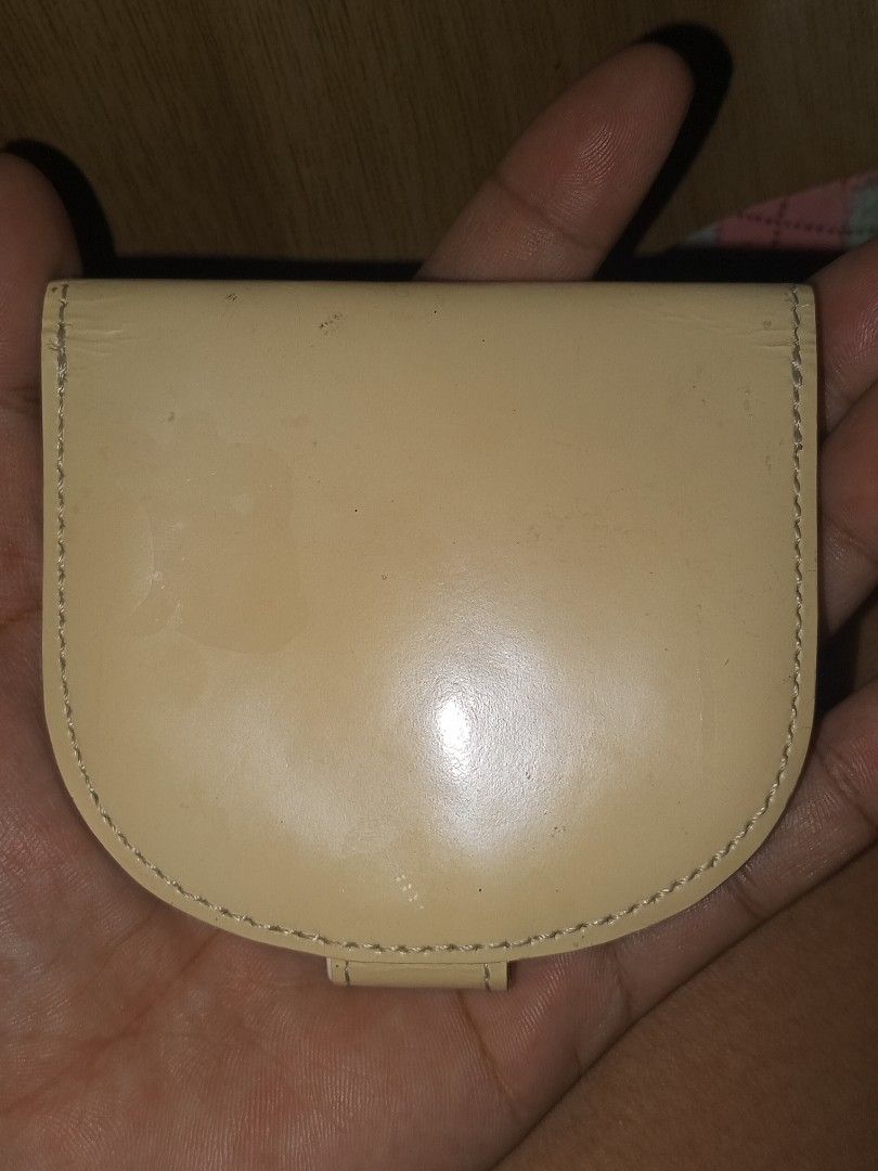 Pierre Cardin Paris Coin Pouch (Category: Purses & Pouches) located in Magalang. Submitted by zeiansoria64090 (Listing ID 1445800048, Image 2). Description: - Cream colored coin pouch from Pierre Cardin Paris - Features a gold button closure - Interior is black - Shows some signs of wear on exterior and interior, particularly on the white flap - Still functional for holding coins or small essentials.