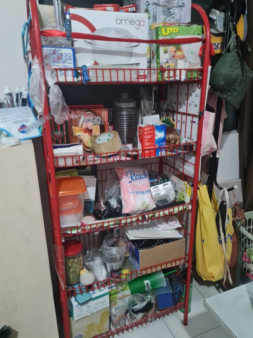Red Metal Storage Rack with Shelves (Category: Shelves, Cabinets & Racks) located in Quezon City. Submitted by declutter1990 (Listing ID 1445794338, Image 3). Description: - Sturdy red metal storage rack - Multiple shelves and compartments - Ideal for organizing various items - Some items still in original packaging - Functional and practical for a tidy space - Ready for a new home.