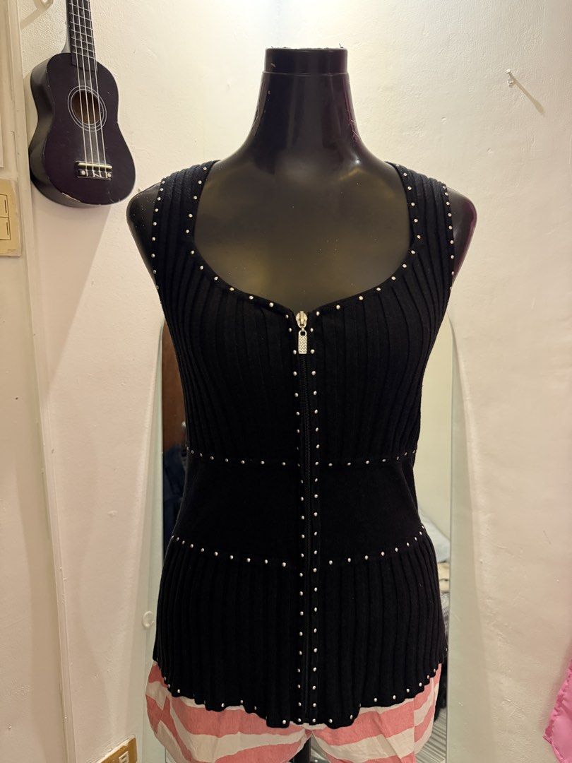 Sleeveless Ribbed Top with Studs and Zipper (Category: Sleeveless) located in Caloocan City. Submitted by prettyplease000 (Listing ID 1445929649, Image 2). Description: - Black ribbed sleeveless top - Zipper down the front - Stud details on neckline, zipper, and waist - Fitted silhouette - Versatile: great for layering or wearing on its own.