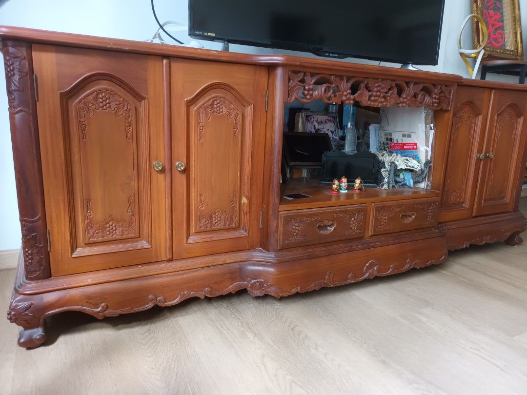 Solid Teak console (Category: TV Consoles) located in Singapore. Submitted by adamzzzzz (Listing ID 1445855732, Image 1). Description: - Solid teak wood console - Large size (over 1.2m) - Features intricate carvings and detailed craftsmanship - Offers ample storage with cabinets and drawers - Warm, rich wood tone - Available for meetup at Sengkang.