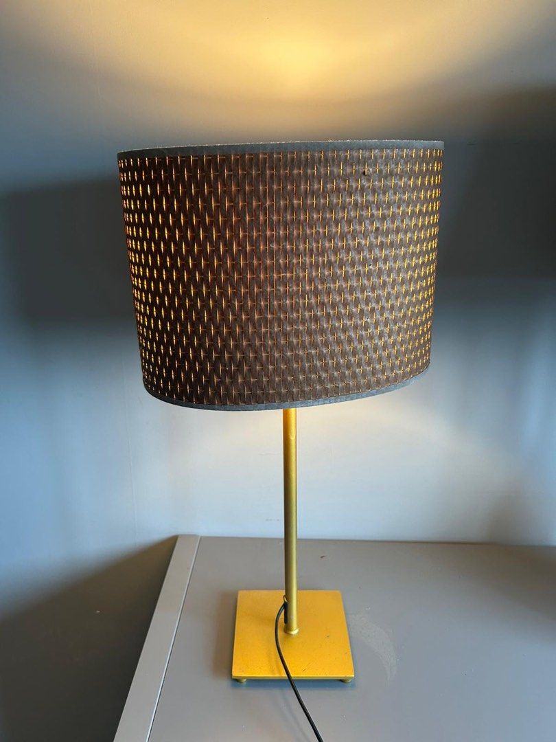 Table Lamp (Category: Lighting) located in Singapore. Submitted by prettylittlegift (Listing ID 1445794113, Image 1). Description: - Elegant gold metal base and stem - Woven shade in dark brown and gold tones - Emits a warm, inviting light - Perfect for study desks or bedside tables - Admiralty collection.