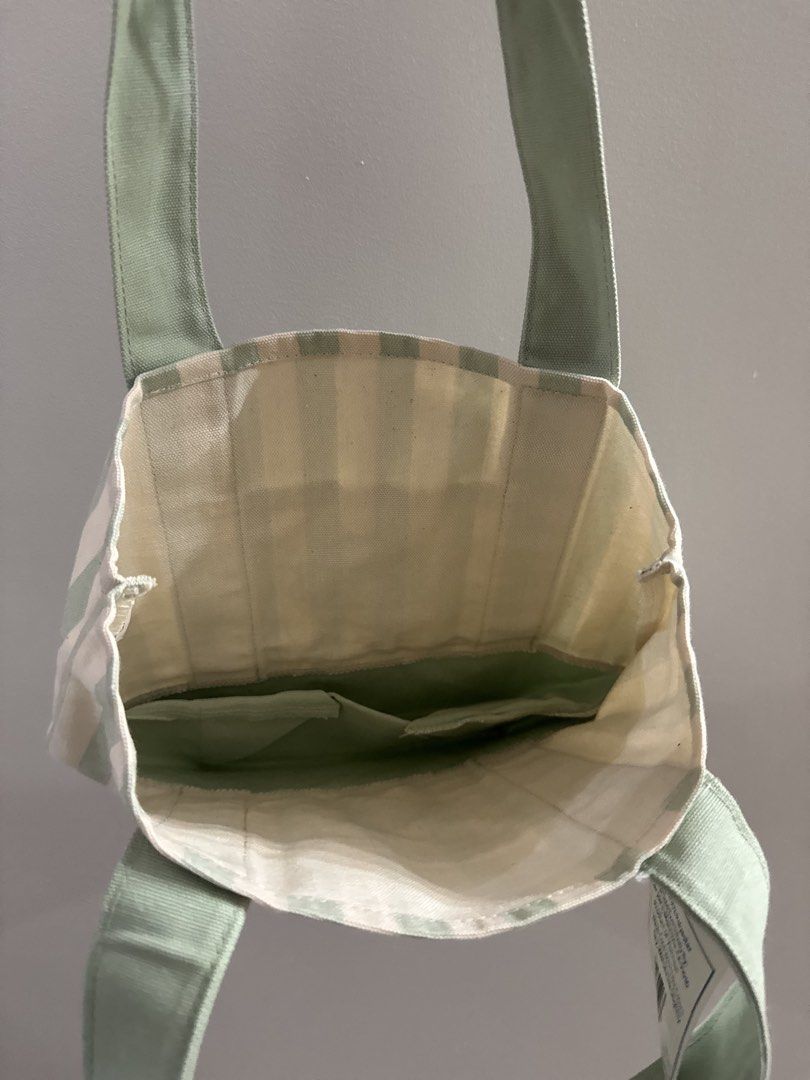 Trader Joe's Striped Mini Canvas Tote Bag (Category: Tote Bags) located in San Pablo. Submitted by simplicitybeaute (Listing ID 1445973753, Image 3). Description: - Cute mini tote bag from Trader Joe's - Classic green and cream stripe pattern - Convenient small front pocket - Internal pockets for organization - Ideal for quick errands or carrying daily essentials - Brand new, still has the original tag attached.