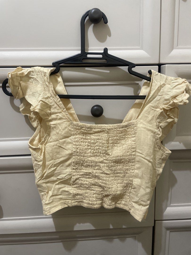 Twisted Front Smocked Crop Top with Flutter Sleeves (Category: Others Tops) located in Makati City. Submitted by thingsoncelovedph (Listing ID 1445947832, Image 2). Description: - Adorable yellow crop top - Features a stylish twisted front detail - Comfortable smocked bodice - Charming flutter sleeves - Versatile: pairs perfectly with high-waisted jeans or skirts - Easy to dress up or down - Made with breathable fabric.