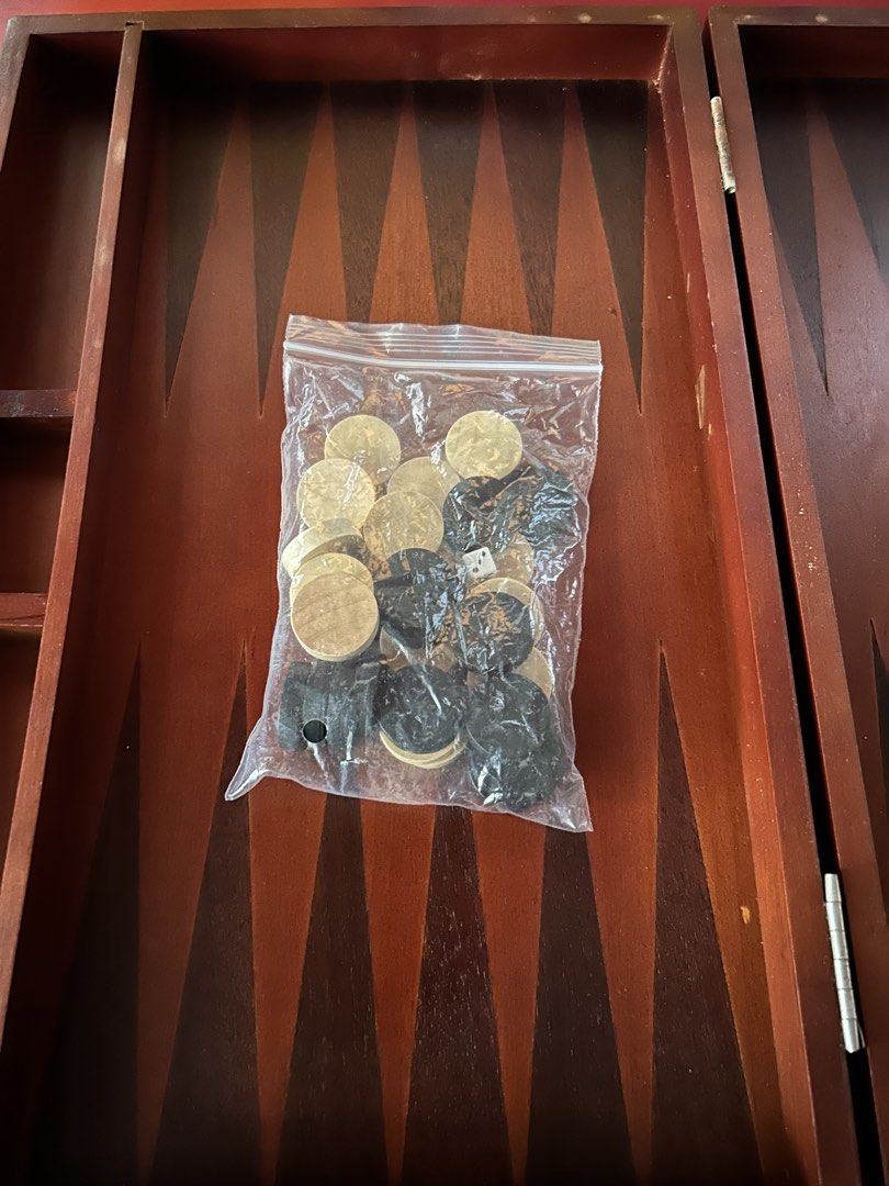 Wooden Backgammon Board Game with Checkers and Dice (Category: Board Games & Puzzles) located in Las Pinas. Submitted by rjmwings (Listing ID 1445842719, Image 3). Description: Vintage Wooden backgammon set. Bought in 1999 Includes checkers in black and light wood colors. Also comes with two dice. The board folds for easy storage and portability: Size 15” wide, 10” length Great for game nights with family and friends. For collectors of vintage bo
