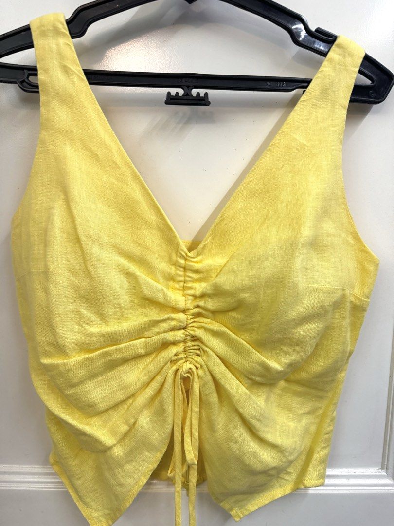 Yellow Linen Ruched V-Neck Crop Top (Category: Blouses) located in Manila. Submitted by mae-v (Listing ID 1445946761, Image 2). Description: - Yellow crop top from Anything Else - Features a ruched front with drawstring tie, adjustable - V-neckline and sleeveless design - Zipper at the back - Versatile for casual or dressed-up looks - Linen - from Bangkok.