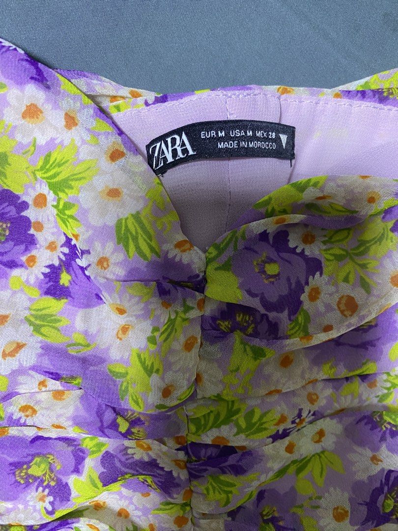 Zara Floral Ruched Camisole Top (Category: Sleeveless) located in Quezon City. Submitted by esmnl (Listing ID 1445907267, Image 2). Description: - Cute purple and green floral camisole from Zara - Features a ruched front detail - Thin spaghetti straps - Lightweight fabric, ideal for warm weather - Versatile for dressing up or down - Size: Medium (M).