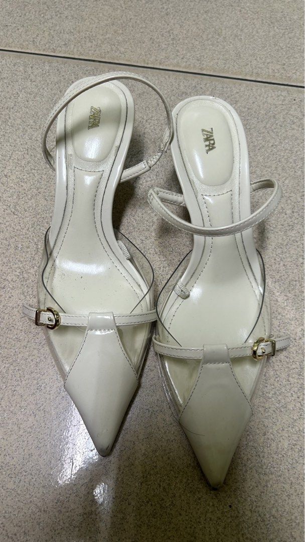 Zara White Slingback Heels with Clear Straps Size 35 (Category: Heels) located in Bacoor. Submitted by iamgraxa (Listing ID 1445920153, Image 1). Description: - Zara white heels - Size: 35 EU - Design: Pointed toe, clear straps - Style: Slingback with adjustable buckle strap - Heel height: Moderate - Condition: Minor signs of wear on soles and heels - Perfect for dressing up or down.
