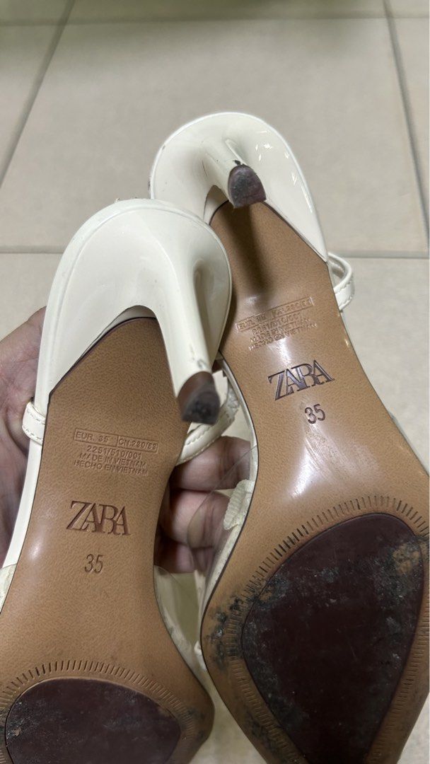 Zara White Slingback Heels with Clear Straps Size 35 (Category: Heels) located in Bacoor. Submitted by iamgraxa (Listing ID 1445920153, Image 2). Description: - Zara white heels - Size: 35 EU - Design: Pointed toe, clear straps - Style: Slingback with adjustable buckle strap - Heel height: Moderate - Condition: Minor signs of wear on soles and heels - Perfect for dressing up or down.