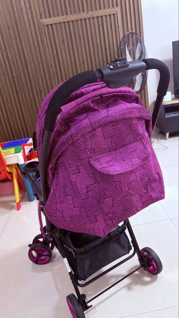 Apruva Stroller - Pink/Purple Geometric Pattern (Category: Strollers) located in Teresa. Submitted by bestfinds4u (Listing ID 1446073123, Image 3). Description: - Fun pink and purple geometric print - Canopy for sun protection - Tray with cup holders - Convenient storage basket underneath - Secure harness for safety - Easy to maneuver with swivel wheels - Ideal for walks and outings - FREE cotton cushion for comfort.