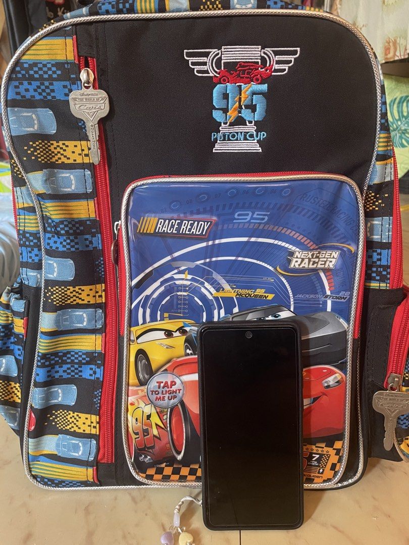 Disney Pixar Cars Piston Cup Backpack (Category: Babies & Kids Fashion) located in Calamba. Submitted by rlin08 (Listing ID 1446020525, Image 2). Description: - Features Lightning McQueen and friends from the Cars Piston Cup. - Ideal for school or travel. - Spacious interior for all your essentials. - Convenient side pockets for water bottles. - Adjustable straps ensure a comfortable fit. - Fun and exciting design for any Cars enthusiast..