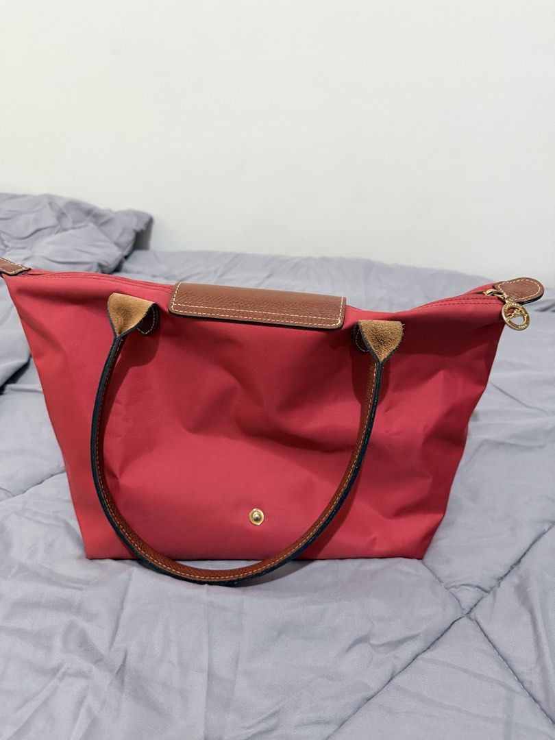 Longchamp Le Pliage Tote Bag Red (Category: Luxury Bags & Wallets) located in Manila. Submitted by klowibaby (Listing ID 1446059710, Image 2). Description: - Classic red Longchamp tote bag - Durable nylon body with genuine leather handles and trim - Secure zipper closure with snap button flap - Spacious interior, perfect for daily essentials, work, or travel.