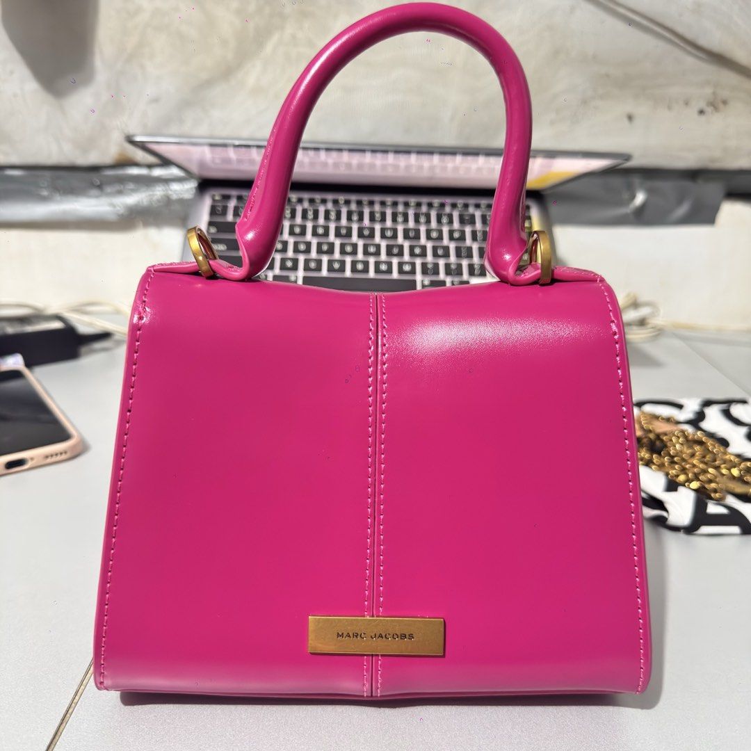 Marc Jacobs Pink Patent Leather Top Handle Bag (Category: Luxury Bags & Wallets) located in Mabalacat. Submitted by kay_miscak (Listing ID 1446057764, Image 3). Description: - Brand: Marc Jacobs - Material: Pink patent leather - Features: Gold chain detail on front flap - Carrying Options: Top handle and detachable shoulder strap - Interior: Clean - Includes: Dust bag - Style Tip: Adds a vibrant pop of color to any outfit -available in yellow col