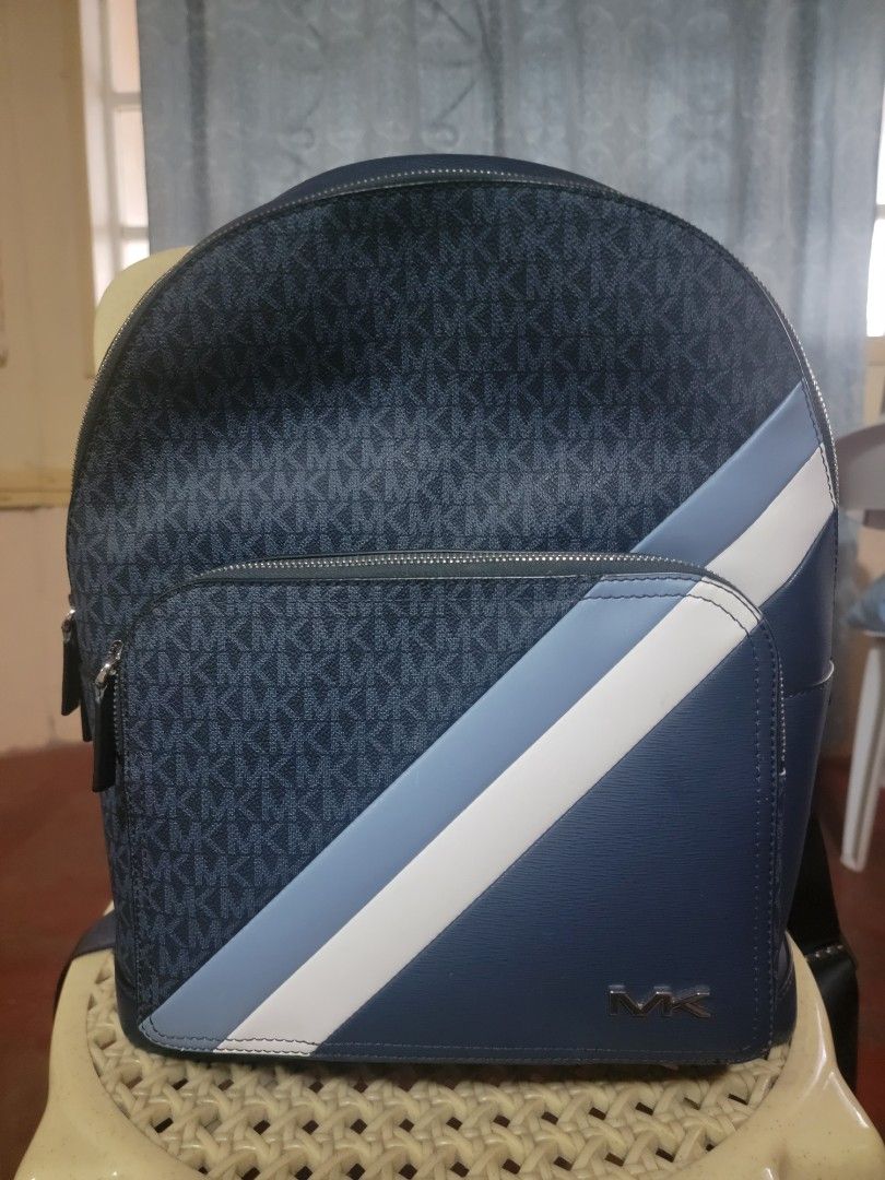 Michael Kors MK (Category: Luxury Bags & Wallets) located in Aguinaldo. Submitted by rhoullcla063142 (Listing ID 1446037580, Image 1). Description: ✅ Type: Premium Casual / Office / Travel Backpack ✅ Color: Navy Blue / Denim Blue with White & Light Blue Accents ✅ Material: High-quality coated canvas with MK monogram print + smooth synthetic leather trims ✅ Style: Modern striped design, silver-tone metal MK logo hardware.