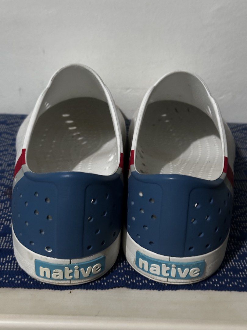 Native Shoes White Perforated Slip-On Sneakers (Category: Sneakers) located in Davao. Submitted by relovedpicks (Listing ID 1446124242, Image 2). Description: - White Native shoes - Breathable perforated design - Red and blue stripe detail on heel - Easy slip-on style - Perfect for casual wear or water activities - Soles show some wear, but plenty of life remaining -condition 9.8/10 .