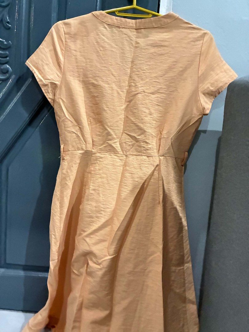 Peach Button-Up Midi Dress with Collar (Category: Dresses) located in Quezon City. Submitted by mnqfinds (Listing ID 1446113461, Image 2). Description: - Chic peach midi dress - Short sleeves and button-up front - Elegant collar detail - Fabric with a subtle sheen - Flattering pleated skirt - Convenient pockets included - Versatile for casual outings or special events.