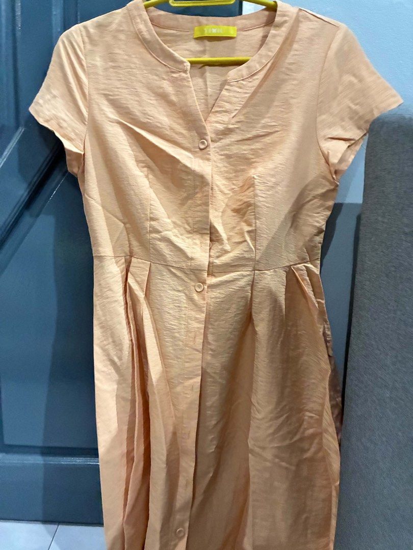 Peach Button-Up Midi Dress with Collar (Category: Dresses) located in Quezon City. Submitted by mnqfinds (Listing ID 1446113461, Image 1). Description: - Chic peach midi dress - Short sleeves and button-up front - Elegant collar detail - Fabric with a subtle sheen - Flattering pleated skirt - Convenient pockets included - Versatile for casual outings or special events.