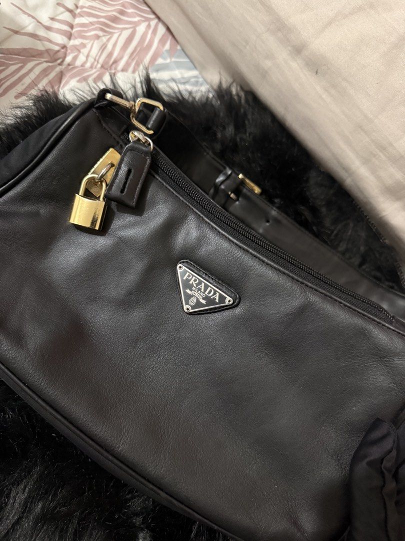 Prada Re-Edition 2000-style Shoulder Bag (Category: Luxury Bags & Wallets) located in Manila. Submitted by adivathrift (Listing ID 1446090320, Image 1). Description: Prada Re-Edition 2000-style Shoulder Bag chic black mini shoulder bag with Prada triangle logo detail, gold-tone hardware, zip closure, and lock charm. It has a classy vintage baguette shape, easy to style for casual or dressy fits. Thrifted from Europe. Authenticity is unverified. S