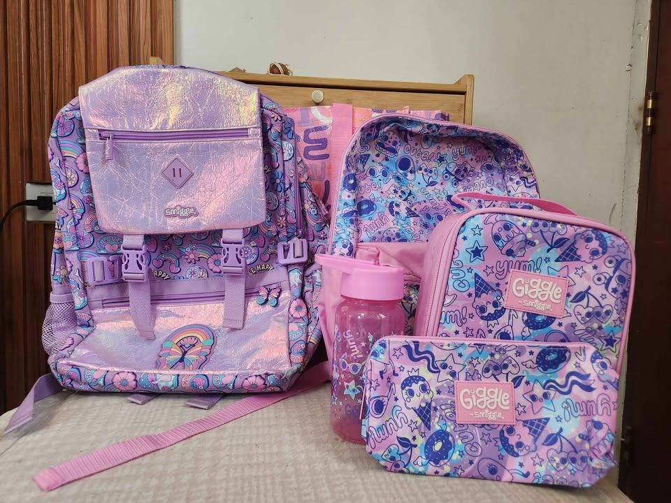 Smiggle Backpack, Lunchbox, Pencil Case, Water Bottle & Tote Bag (Category: Babies & Kids Fashion) located in Santa Rosa. Submitted by serpedoo (Listing ID 1445997085, Image 1). Description: ✨ Smiggle + Giggle Set – Cute & Practical Bundle! ✨ Selling as a set or individually 💕 💰 Price: • ₱4,000 for everything • ₱2,200 each bag 👜 Smiggle Foldover Backpack – Butterfly Light Purple (Left) • Capacity: 22L • Size: 30 x 45 x 13 cm • With carry handl