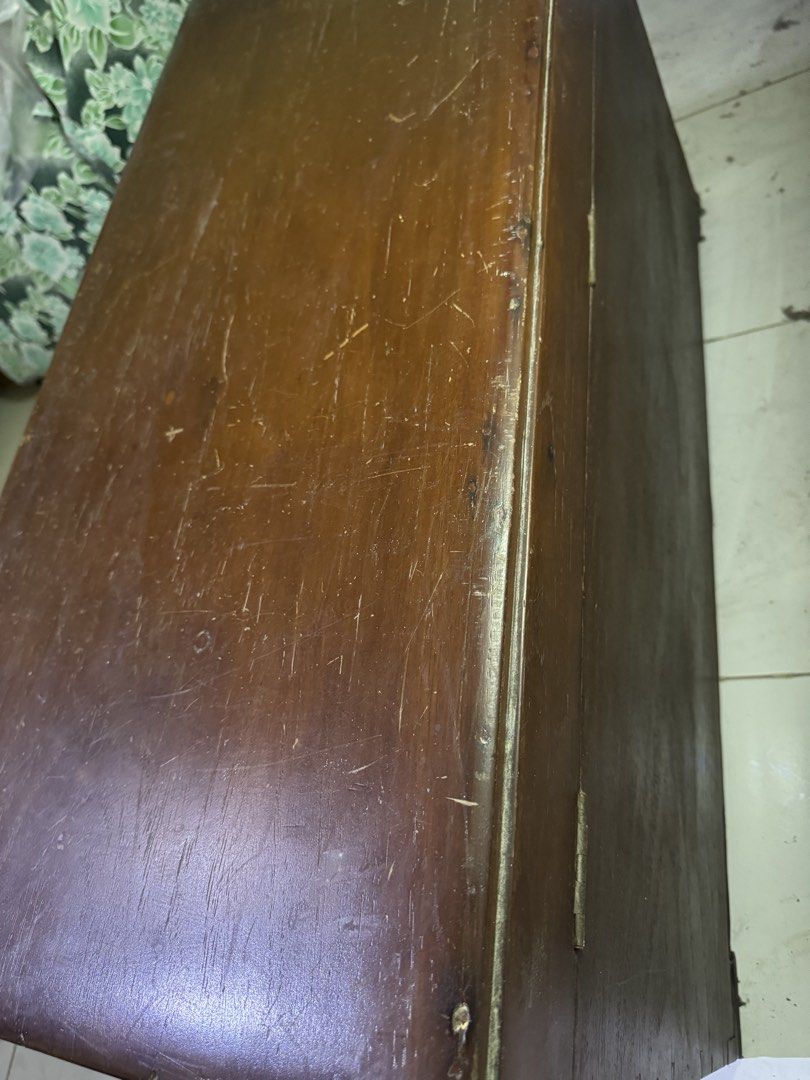 Vintage Wooden Storage Chest Trunk (Category: Shelves, Cabinets & Racks) located in Las Pinas. Submitted by emdjss (Listing ID 1446034137, Image 3). Description: - Solid wood chest with a rich, dark brown finish. - Sturdy metal handle on the side for easy carrying. - Front keyhole for added security (key not included). - Interior dividers help organize your items. - Exhibits charming signs of age like scratches and scuffs, adding to its vintage c