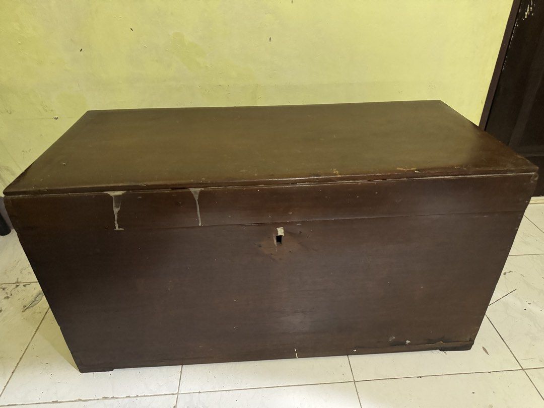 Vintage Wooden Storage Chest Trunk (Category: Shelves, Cabinets & Racks) located in Las Pinas. Submitted by emdjss (Listing ID 1446034137, Image 1). Description: - Solid wood chest with a rich, dark brown finish. - Sturdy metal handle on the side for easy carrying. - Front keyhole for added security (key not included). - Interior dividers help organize your items. - Exhibits charming signs of age like scratches and scuffs, adding to its vintage c